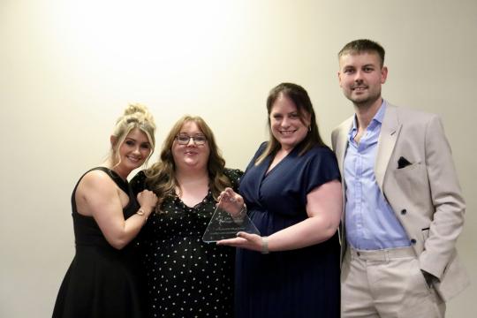 A group of people holding an award